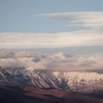 Mountain Landscapes - A scenic view of snow-capped mountains under a c #10864282