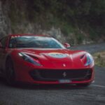 Luxury Cars - A striking red Ferrari sports car navigating a s #13971807