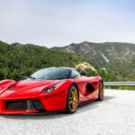 Luxury Cars - A striking red sports car parked on a scenic mou #31192018