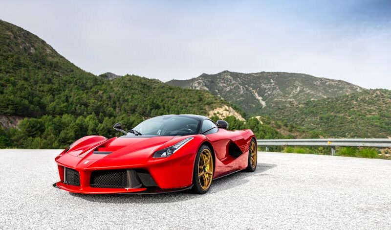 Luxury Cars - A striking red sports car parked on a scenic mou #31192018