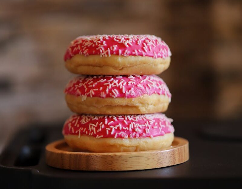 Food Aesthetics - Three pink frosted donuts with sprinkles stacked #31481575