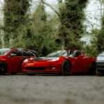 Luxury Cars - Vibrant red sports car parked in lush outdoor se #31727903