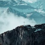 Mountain Landscapes - Stunning view of Swiss Alps with cross atop a ro #34090351
