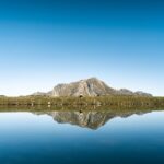 Mountain Landscapes - Calm alpine lake reflects majestic mountain unde #34274165
