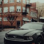 Luxury Cars - Modern black car parked on a rainy urban street  #34998665