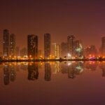 City Architecture - Dramatic cityscape at night with buildings refle #3680903
