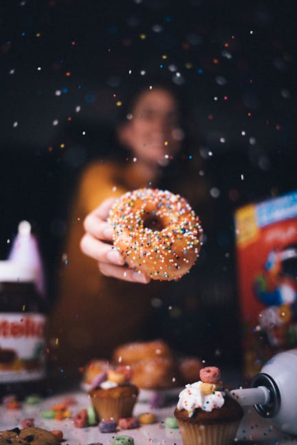 Food Aesthetics - A person holding a donut with vibrant sprinkles  #4707237