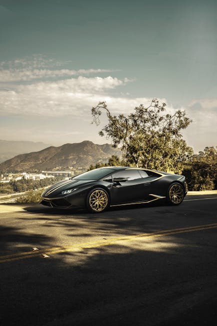 Luxury Cars - A sleek luxury sports car parked on a scenic roa #6601345